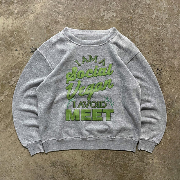 ”I'm a social vegan. I avoid meet“ green text printed shirt